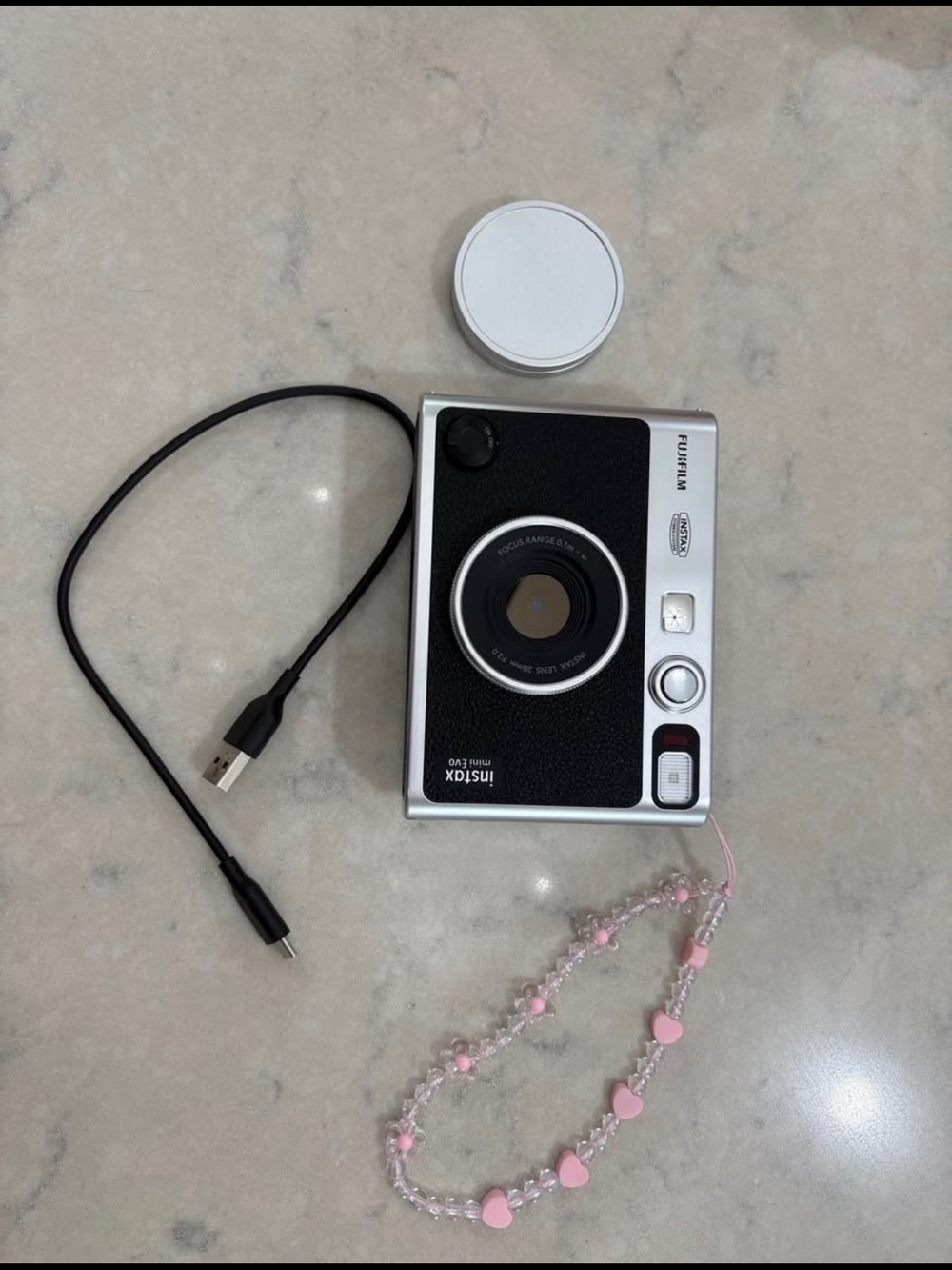 Fujifilm Instax Mini Evo Includes:- lens cover- wrist strap- charging ca